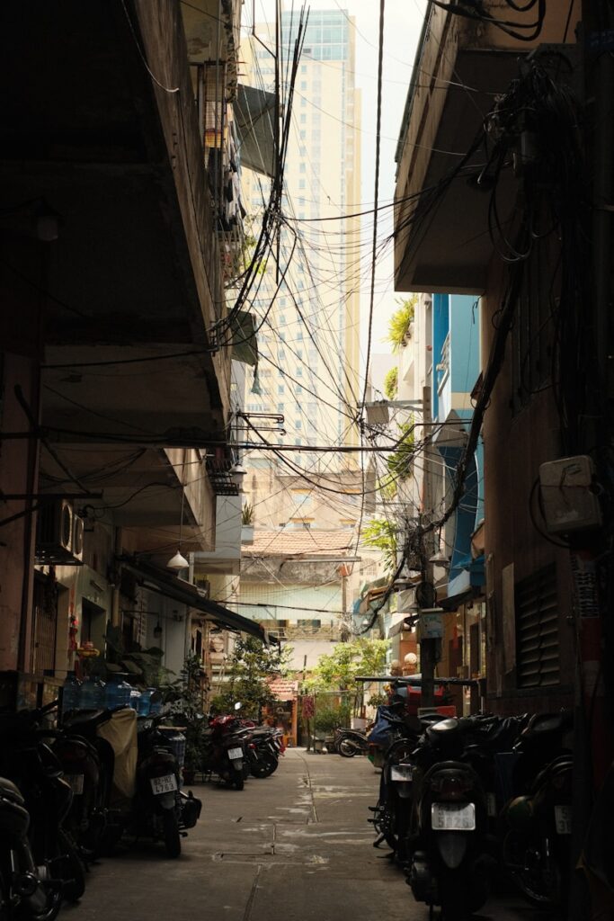 A narrow alley way with many motorcycles parked on both sides