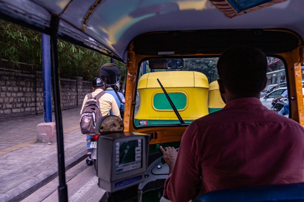 a man driving a yellow bus down a street